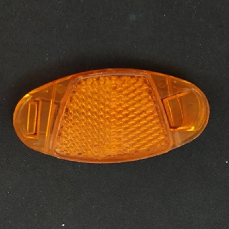 Bicycle spoke reflector showing yellow plastic construction with clip-on attachment for wheel safety