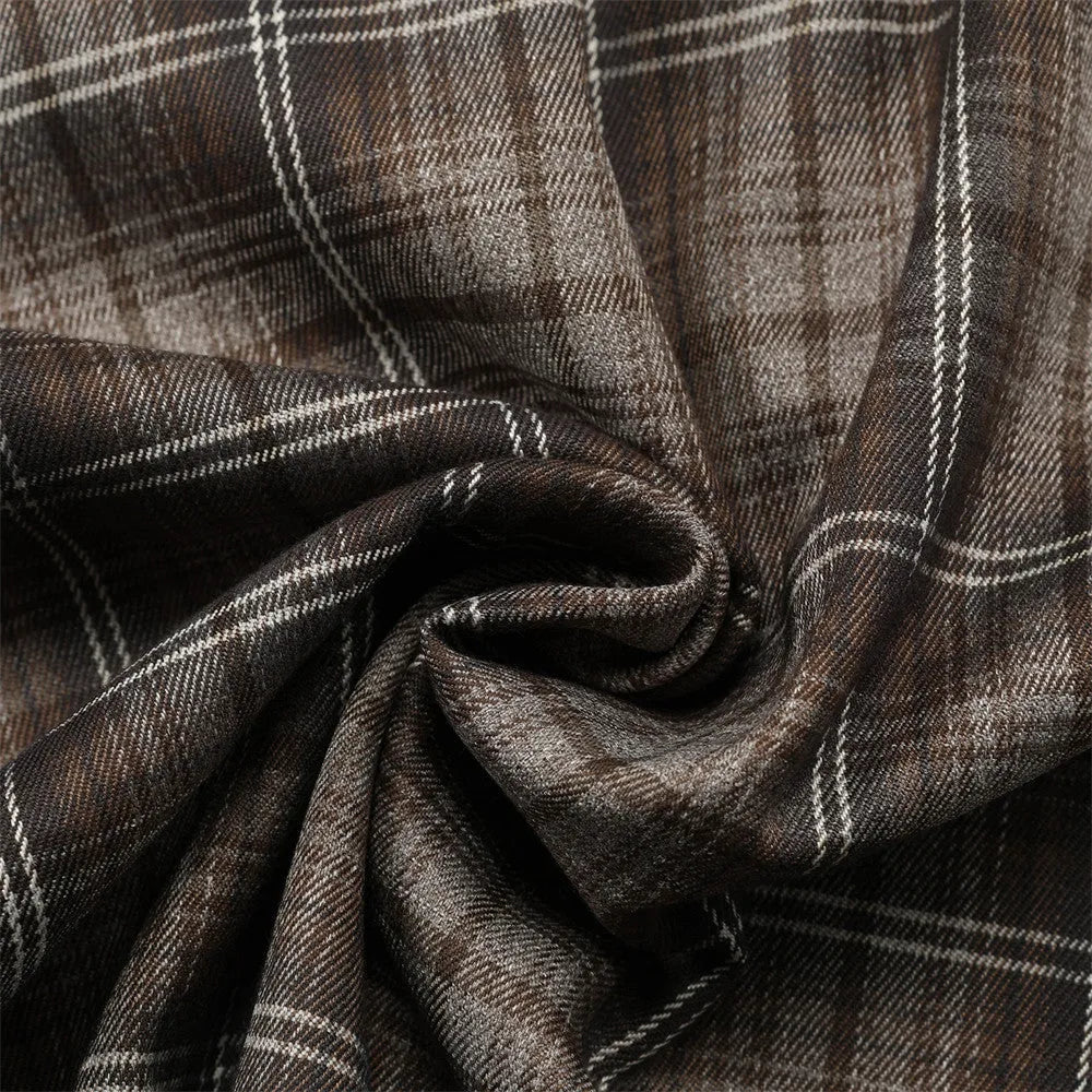 Man wearing a black and brown plaid short sleeve shirt with embroidered letter on lapel
