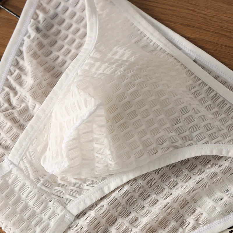 Men's low waist transparent lace underwear in multiple colours on a size chart background.