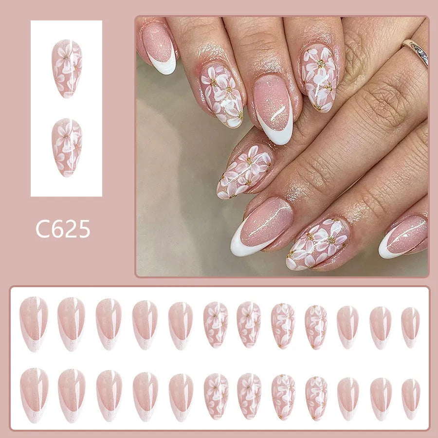 Short almond-shaped press-on nails with French manicure, flower patterns, and glitter accents in colour C625