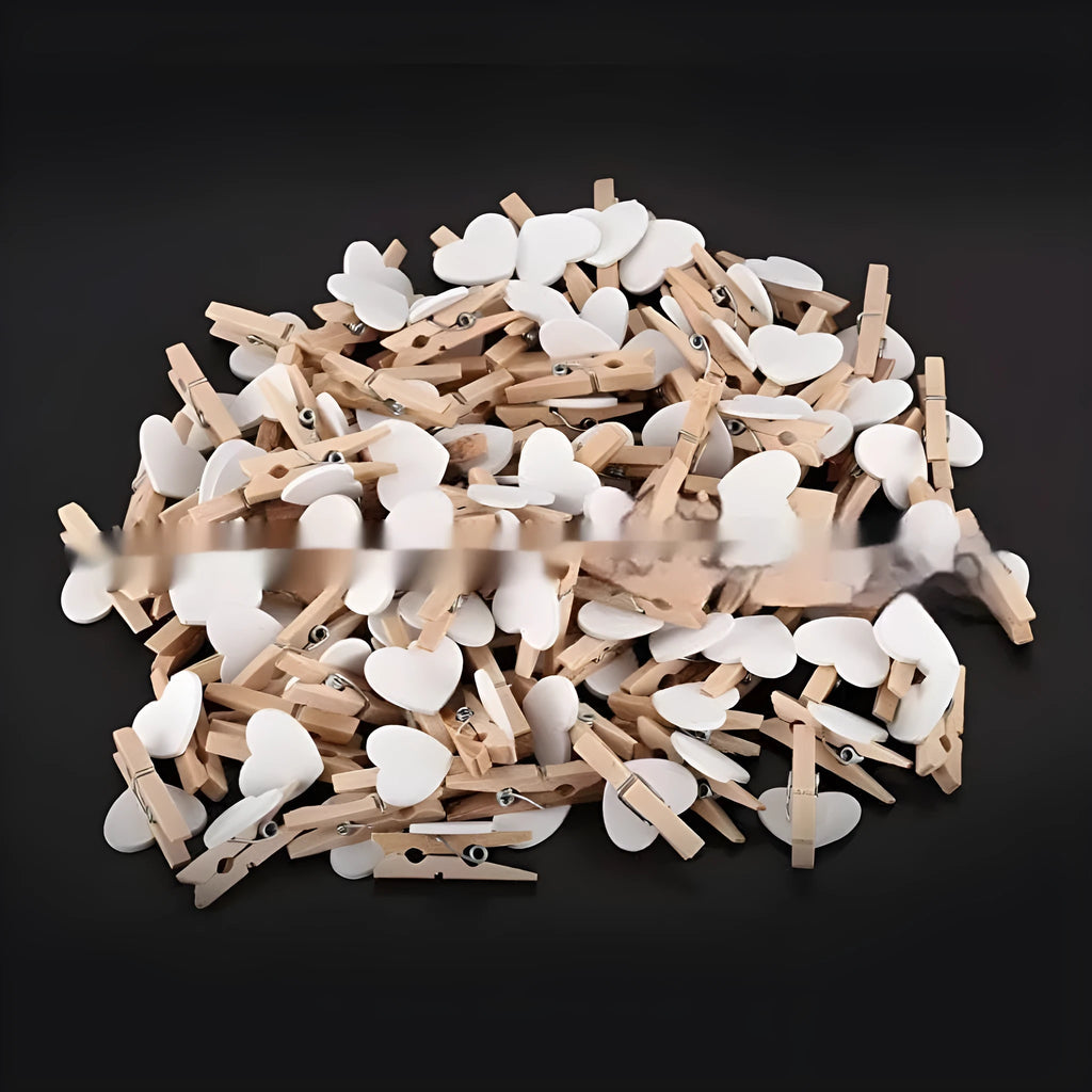 Five handmade solid wood heart-shaped clips in red, white, and pink on a wooden surface.