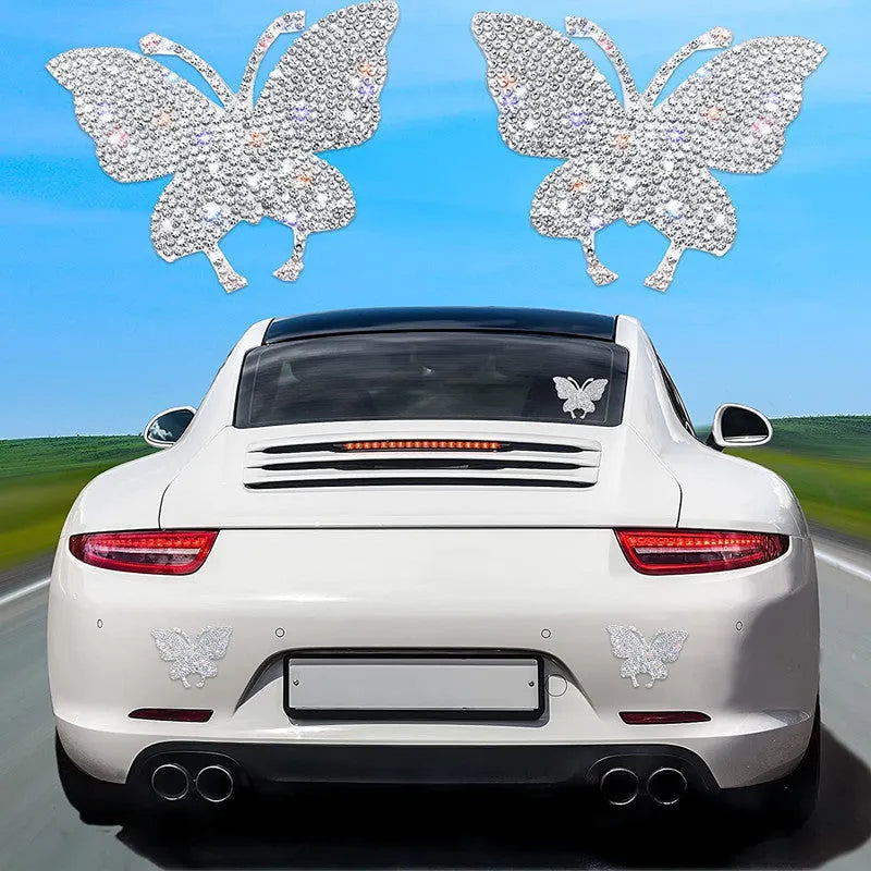 Close-up of a diamond-sparkle glass car sticker in a butterfly or bear paw design on a car surface.