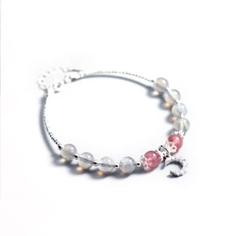 Handmade adjustable bracelet with a natural moonstone and silver crescent moon charm on a wrist.