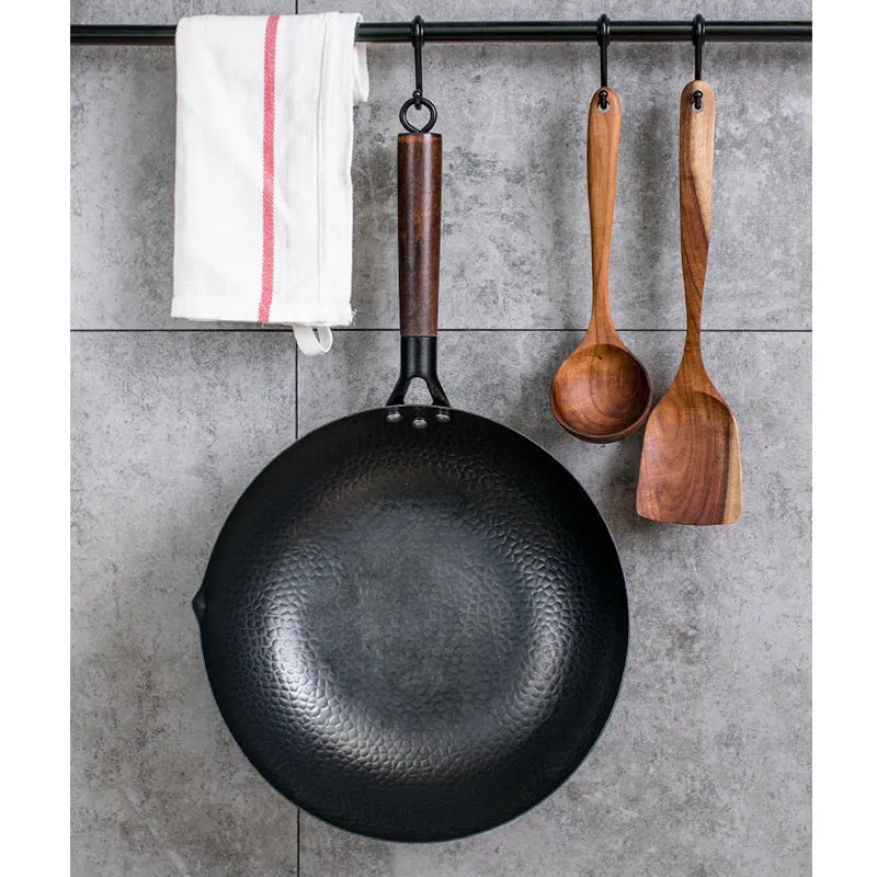 Traditional handmade iron wok pan with wooden handle and induction-compatible base