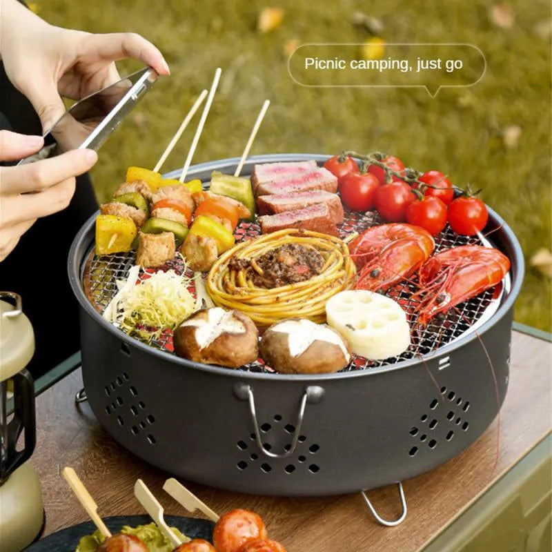 Portable stainless steel BBQ grill with detachable parts and storage bag, shown in grey colour.