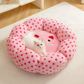 Round pink cat bed with dot pattern and cushion for indoor sleeping