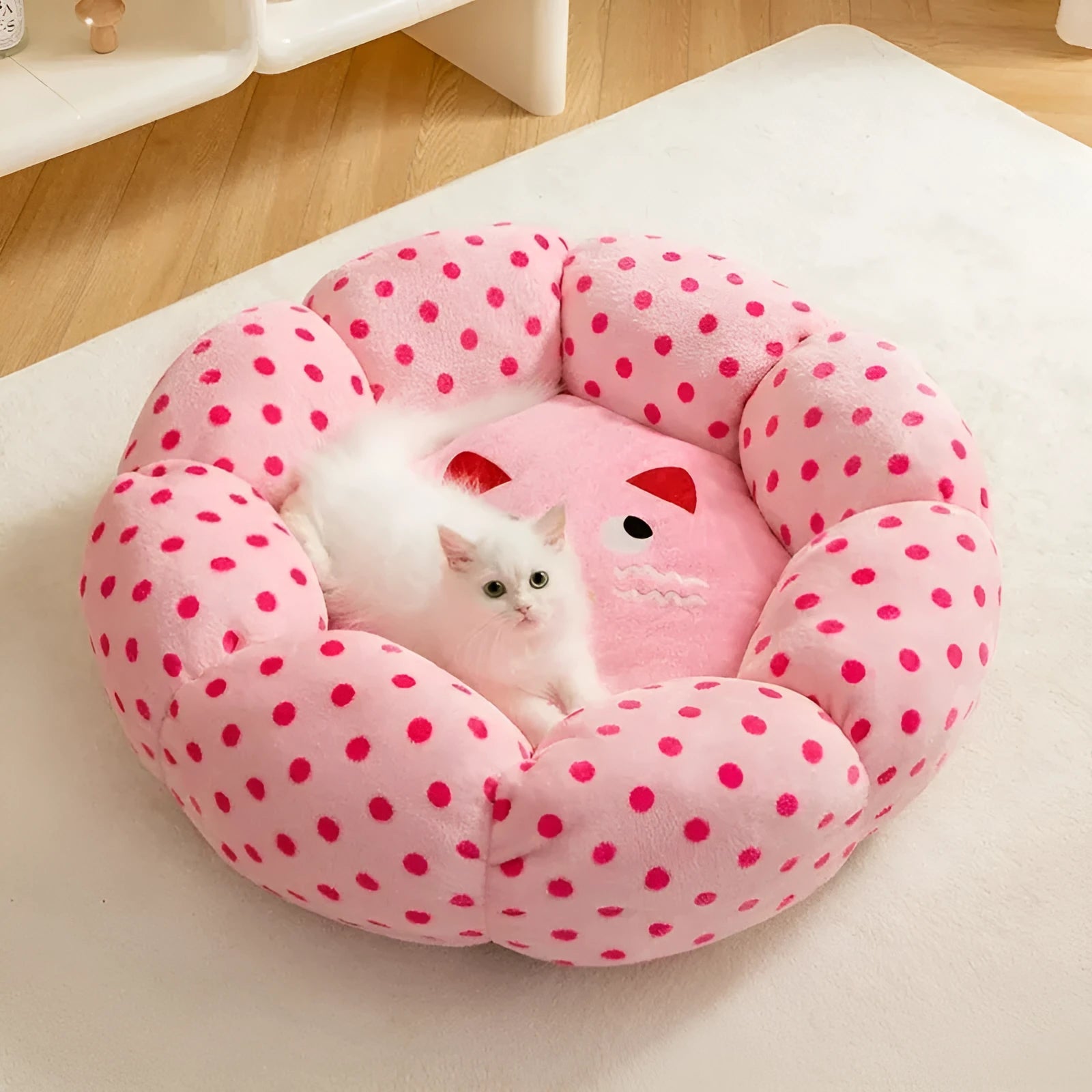 Round pink cat bed with dot pattern and cushion for indoor sleeping