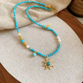 French royal court style necklace with freshwater pearls and a stone sun pendant on an adjustable chain.