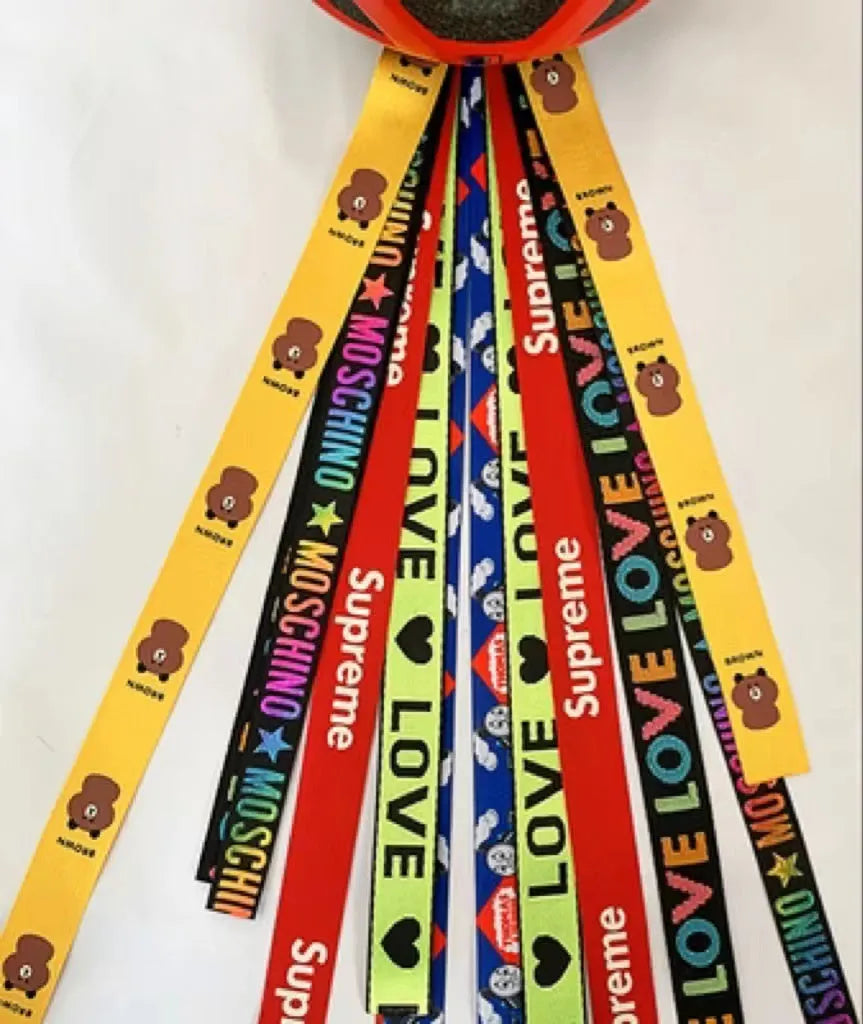Colourful decorative ribbon streamers attached to a children safety helmet for skating or skiing