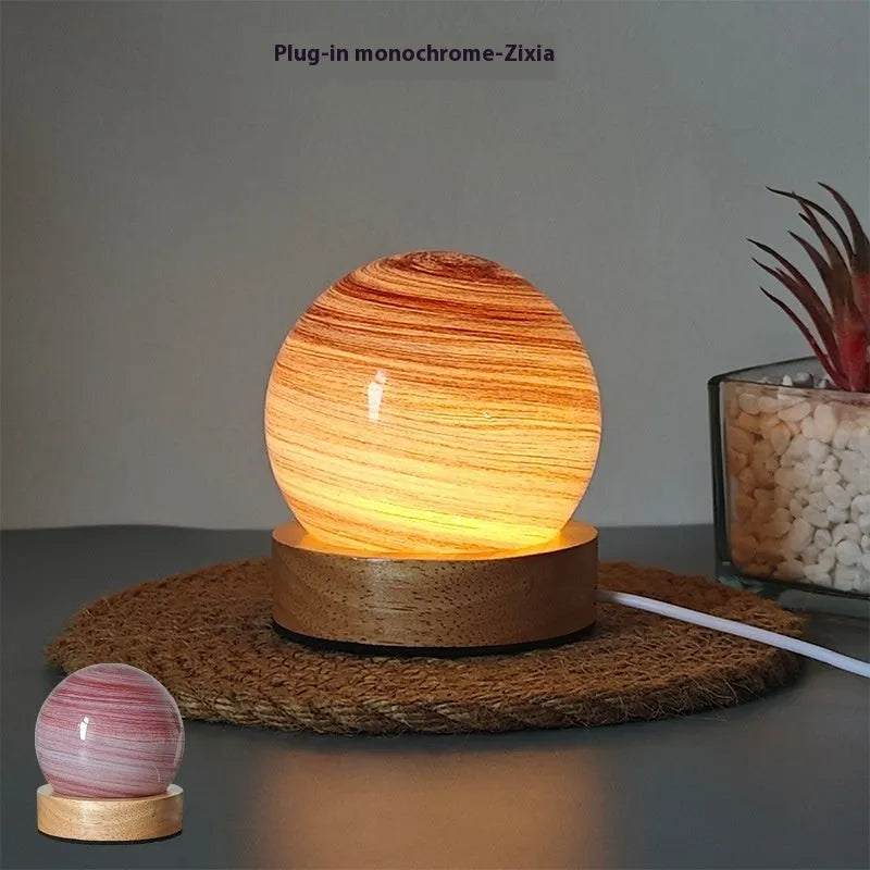 Planet night light with spherical design on base, USB cable connected, showing adjustable three-colour lighting