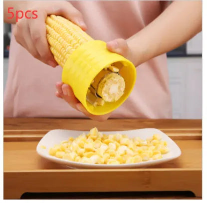 Yellow manual corn thresher with corn-shaped design and stainless steel gear for peeling kernels.