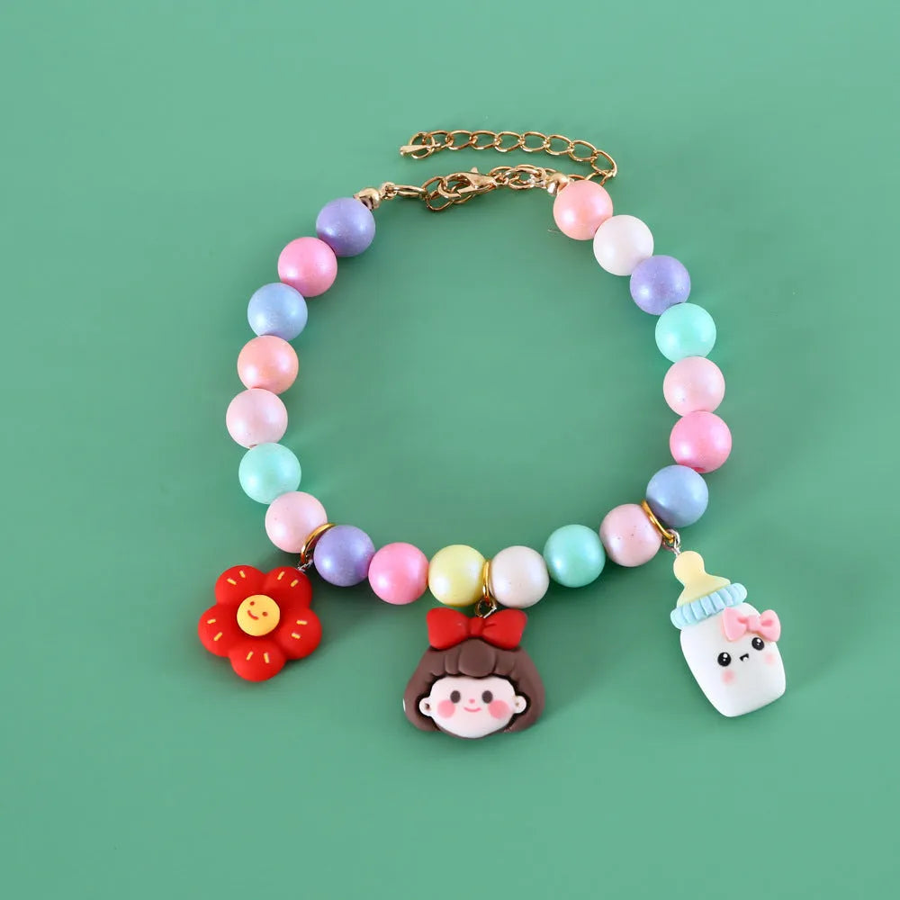 Colourful macaron charm pet collar and matching bracelet set in resin on a white background.