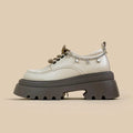 White platform Mary Jane shoes with chunky heel and front lace-up detail on a round toe.