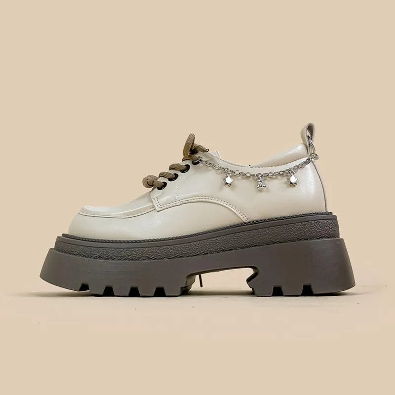 White platform Mary Jane shoes with chunky heel and front lace-up detail on a round toe.
