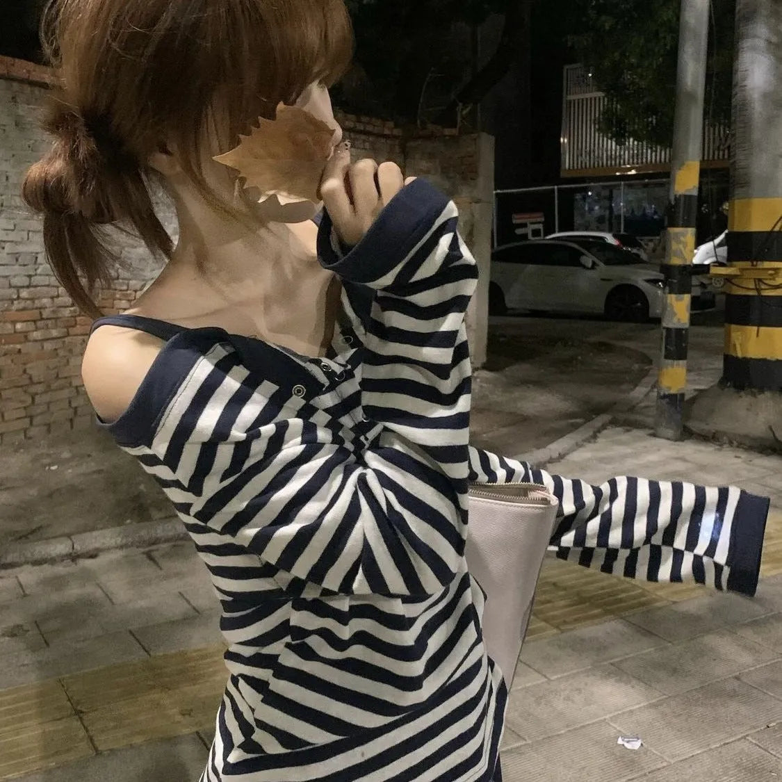 Dark blue oversized women's long-sleeve t-shirt with stripes, button detail, and embroidery on the front.