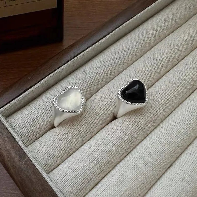 S925 sterling silver adjustable ring with a black agate heart design on a finger.