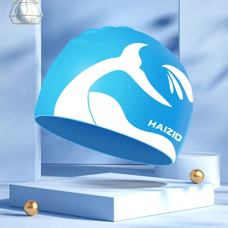 Silicone swimming cap with whale tail pattern and built-in ear protectors in assorted colours.