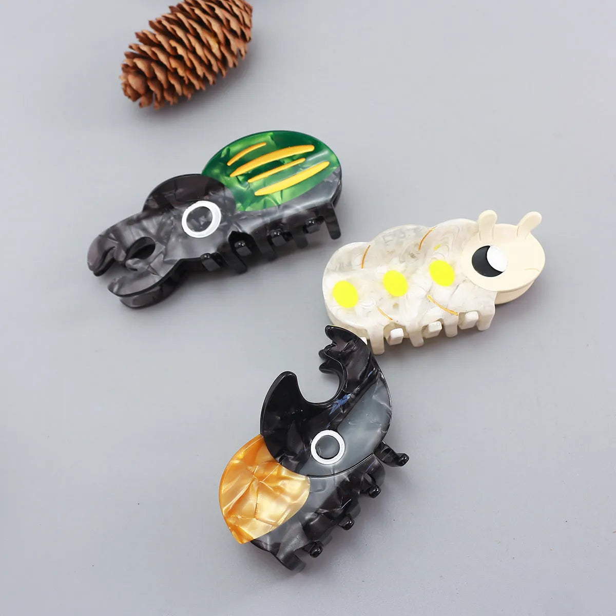 Handmade cellulose acetate insect grip with green beetle, orange beetle, and white caterpillar models for biology study.
