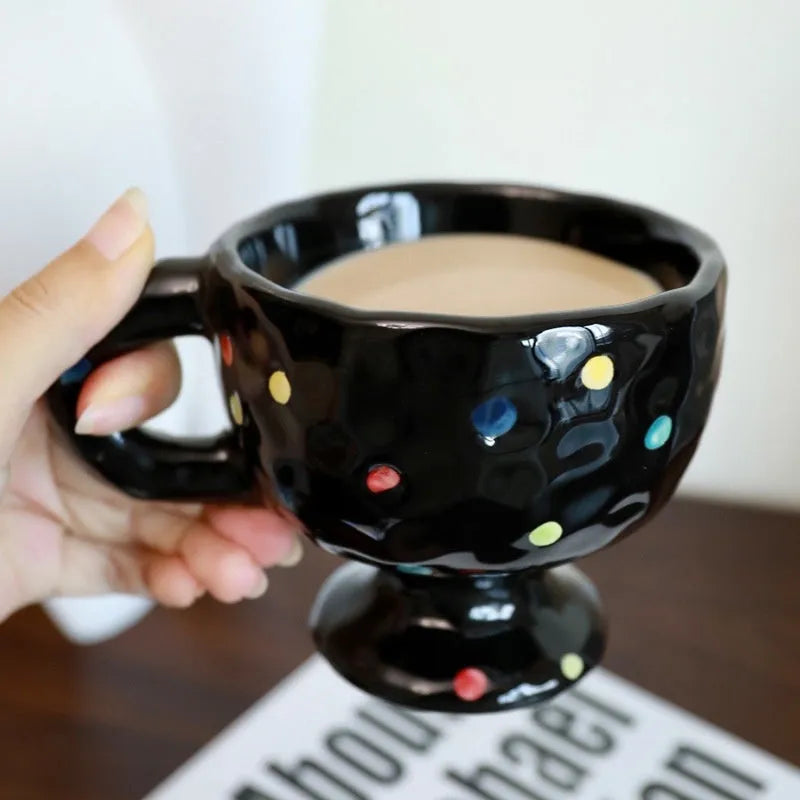 Hand-pinched irregular shaped ceramic mug in a solid colour on a table.