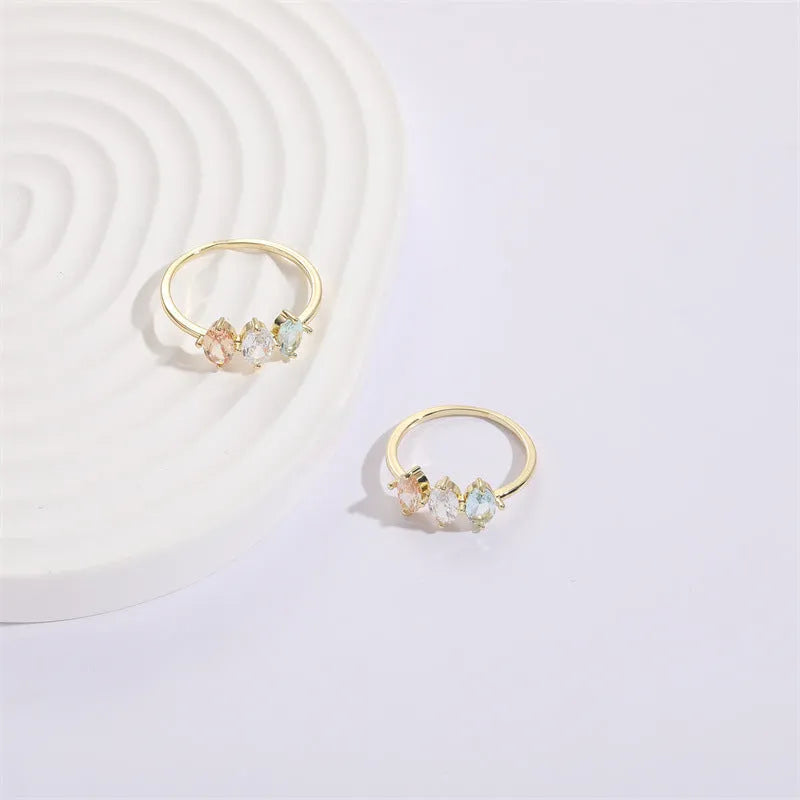 Geometric triangle ring with tricolour zircon stones in horse eye pattern and gold colour finish