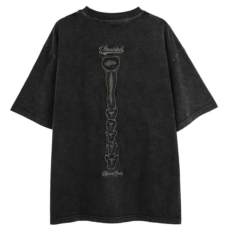 Man wearing a black loose-fit cotton T-shirt with a skull and letter graphic print on the chest.