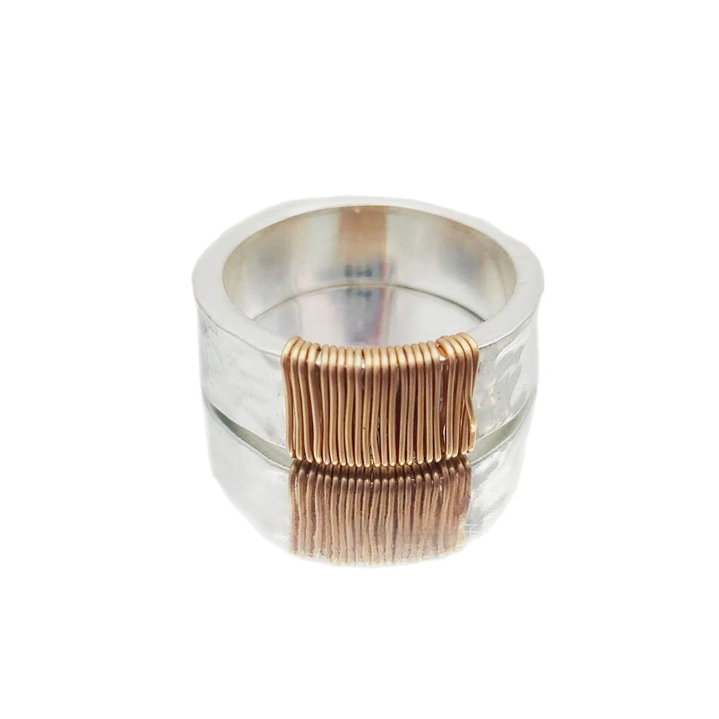Geometric copper bracelet with irregular coil pattern forming silver-gold wide-faced ring design