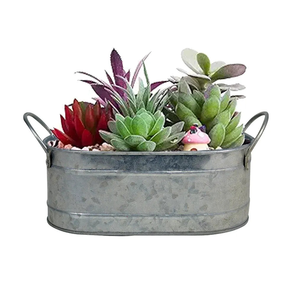 Galvanised iron cylindrical succulent flower pot with a drainage hole on a desk.