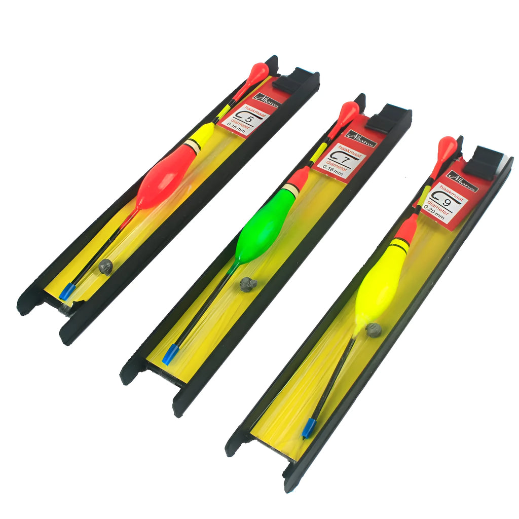 Three plastic vertical fishing floats with wire group and double hook on a dark background