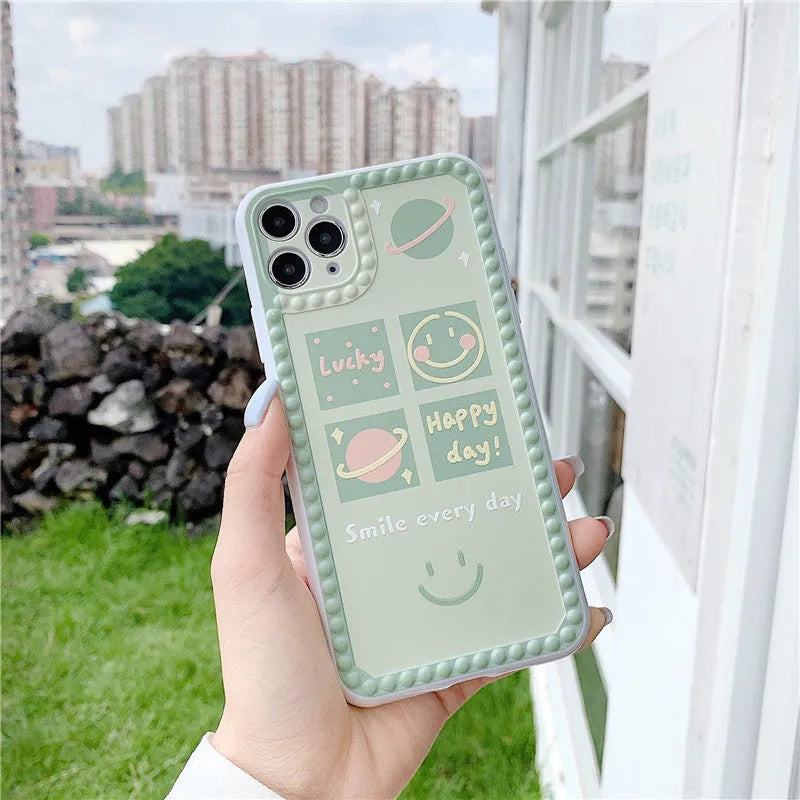 Green TPU phone case with geometric smiley face and polka dot frame design for iPhone.