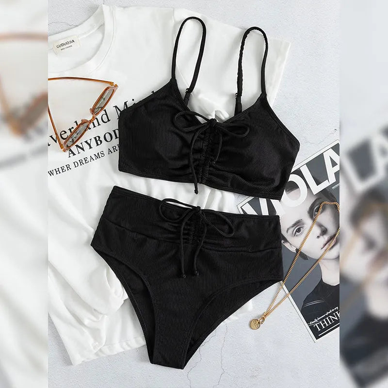 Black women's high-waist bikini with sling split design on shorts and sleeveless top.