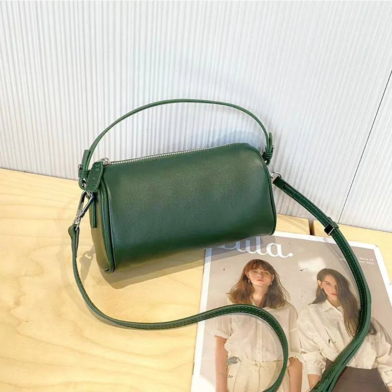 Soft genuine leather cylindrical crossbody phone bag in brown with a single shoulder strap.