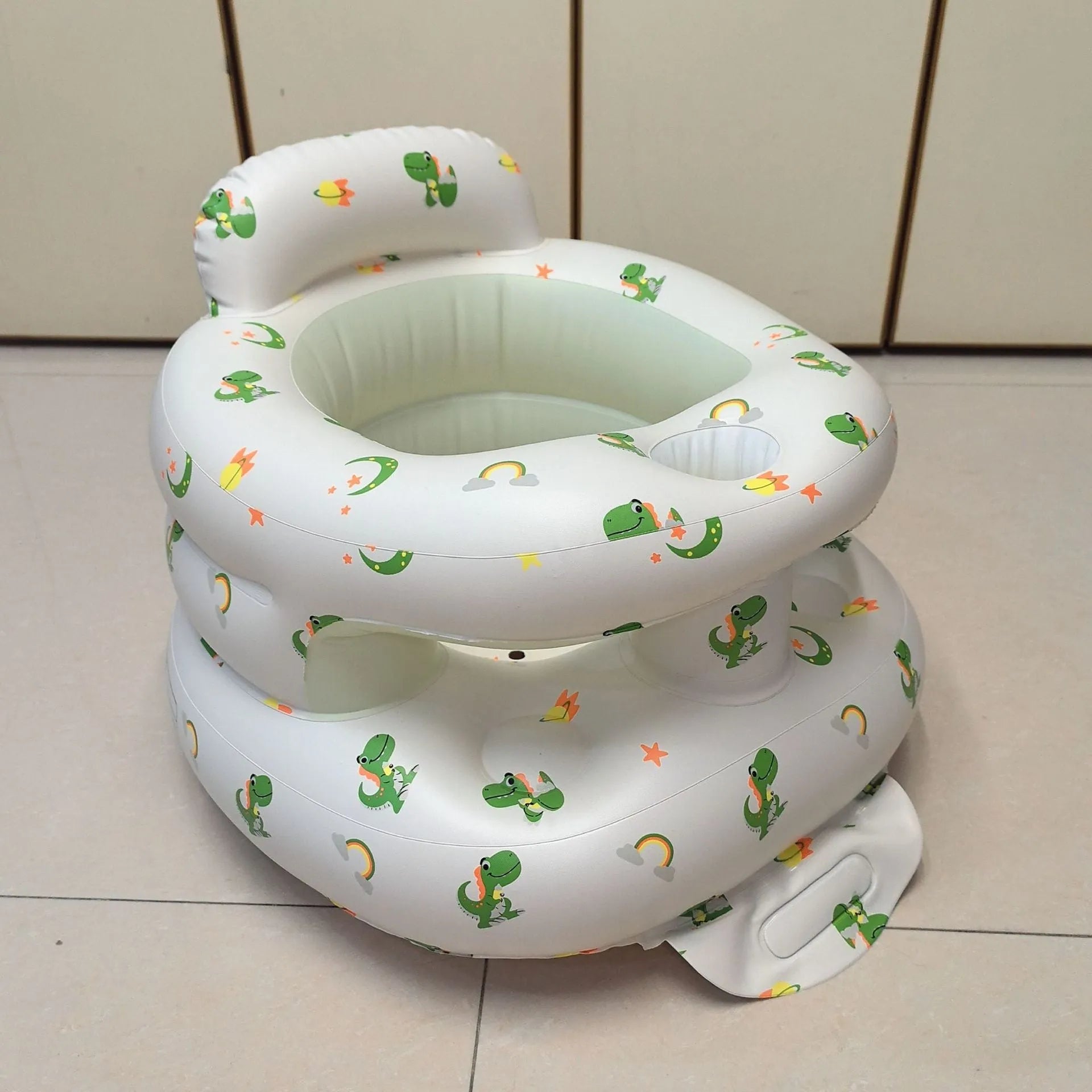 Inflatable infant dining chair in PVC with bear design, deflated beside a baby for scale
