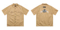 Men's black plus-size loose fit work shirt with a chest pocket and embroidered detail on the sleeve.