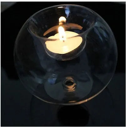 Clear round hollow glass candle holder for a tea light on a table