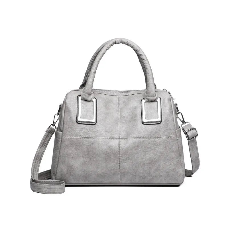 Women's square shoulder bag showing internal phone pocket and document compartment in neutral colour