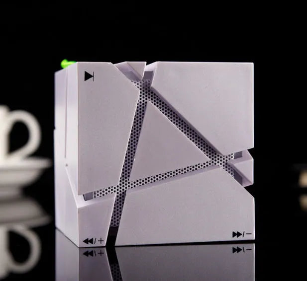 Cube Bluetooth Speaker with colourful lights in black ABS casing, front view on desk