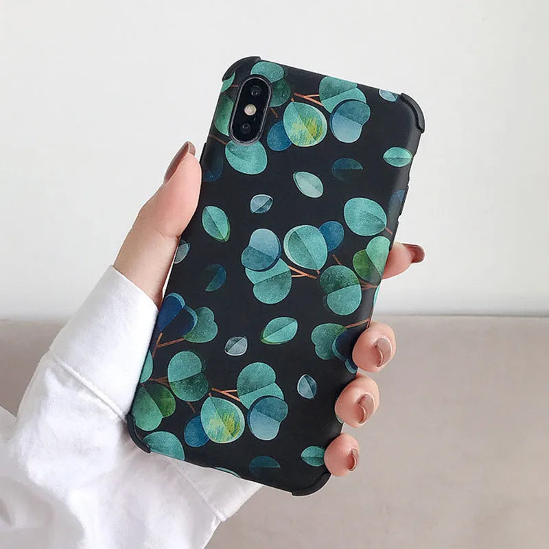 Black silicone iPhone case with a leaf pattern design on a table.