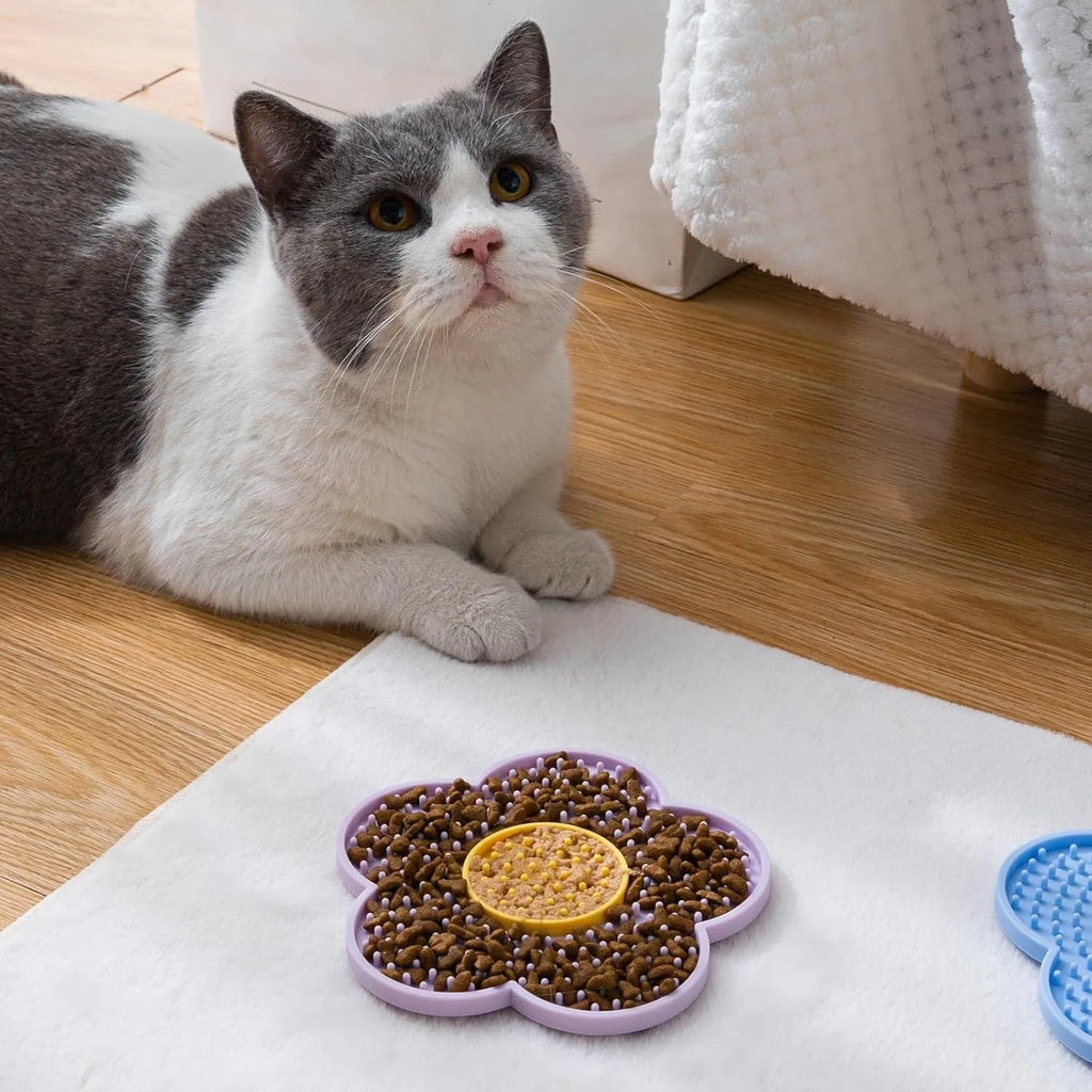 A blue flower-shaped silicone lick mat for pets with four white suction cups on the underside.