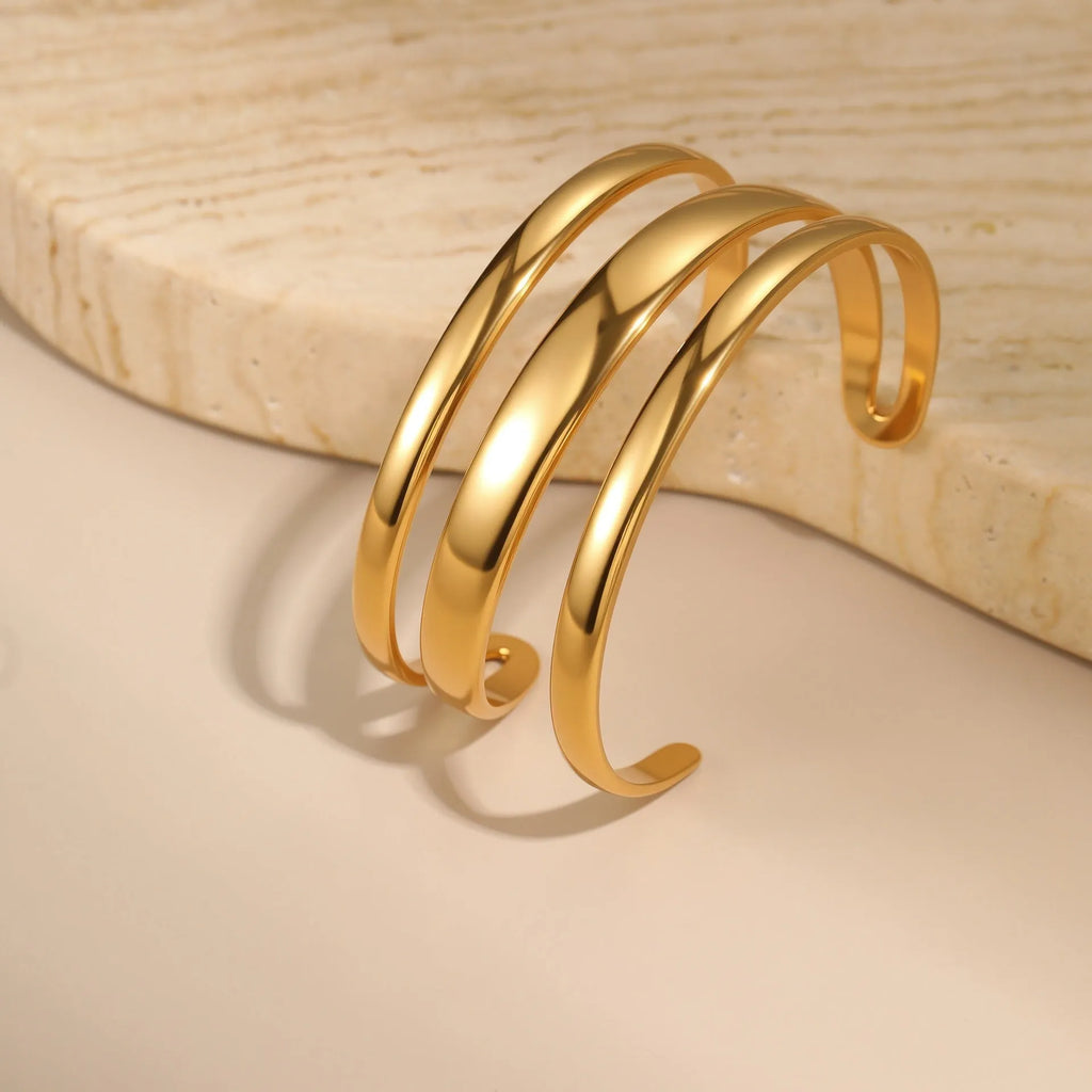 Geometric stainless steel women's bracelet with simple opening, available in gold or steel colour with linear design elements