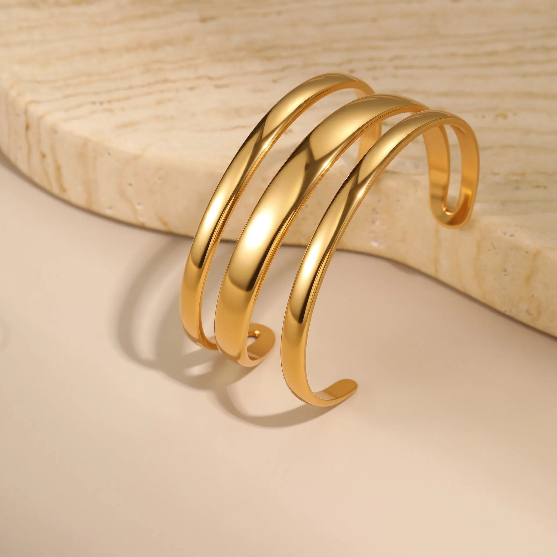 Geometric stainless steel women's bracelet with simple opening, available in gold or steel colour with linear design elements