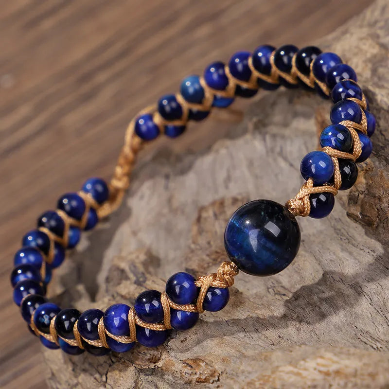 Handmade woven pull bracelet in blue Tigereye or amethyst with geometric design on wrist.