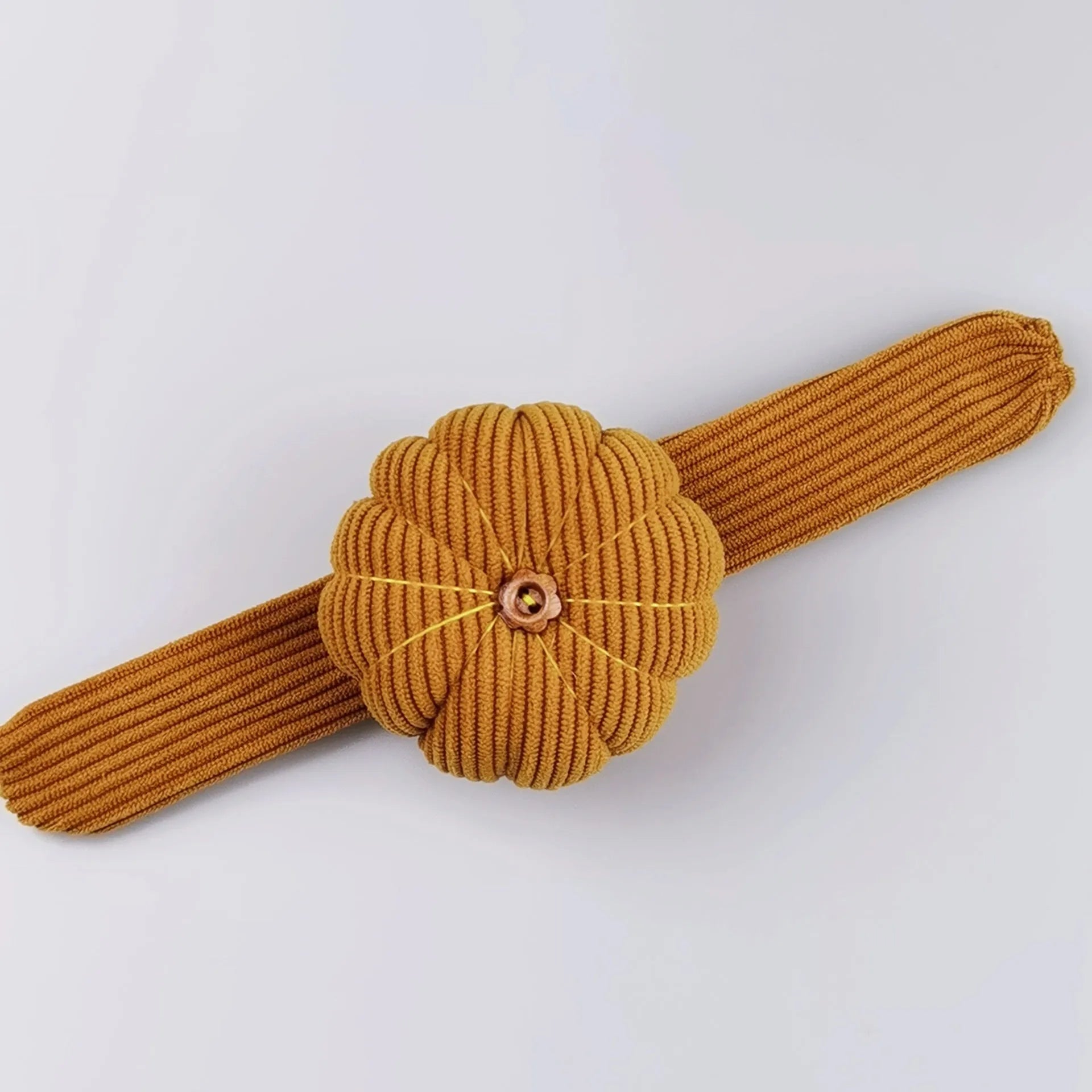 Ring pincushion sewing tool with vertical cutting slot in caramel colour showing fabric cushion and metal ring base