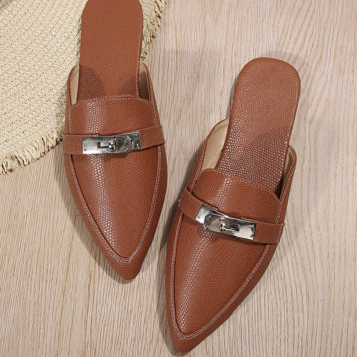 Light brown women's pointed toe low heel slippers with a rubber sole on a plain background.
