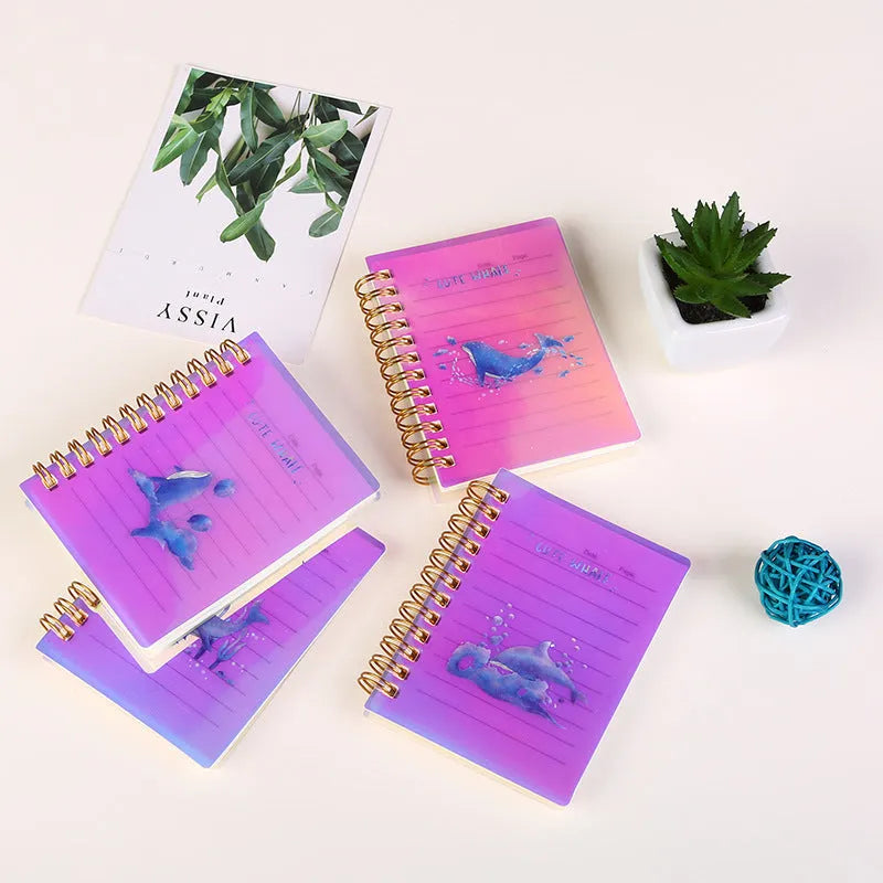 Set of four A7 spiral-bound pocket notebooks with different coloured PP covers showing Constellation, Sakura, Ocean, and Universe designs.