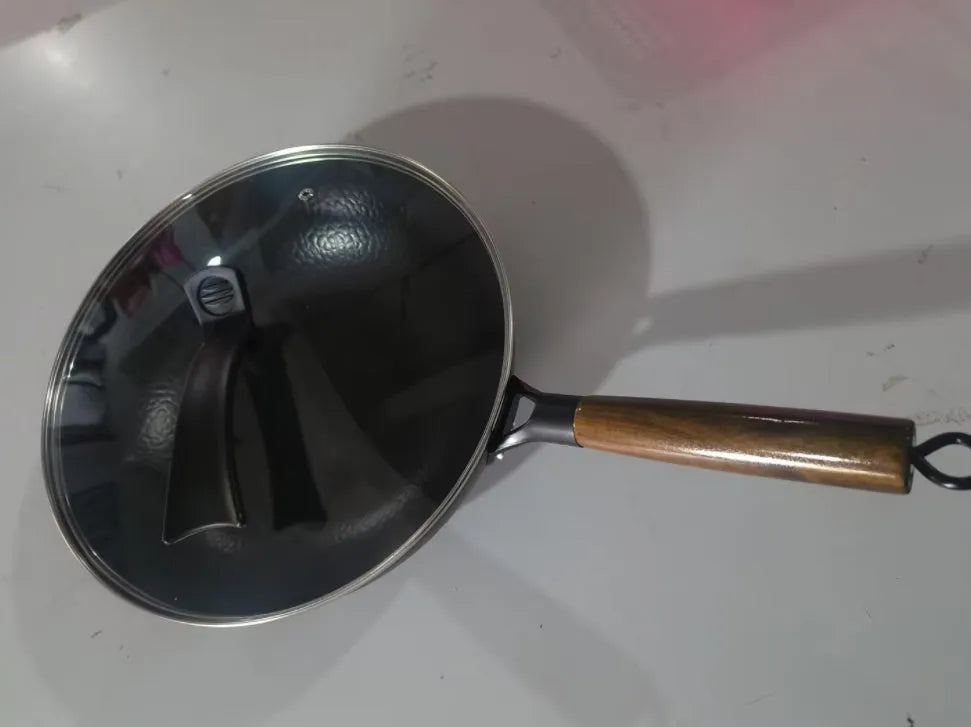 Traditional handmade iron wok pan with wooden handle and induction-compatible base