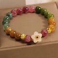 Electroplated tourmaline bracelet with flower and fu character pendant designs in natural colours