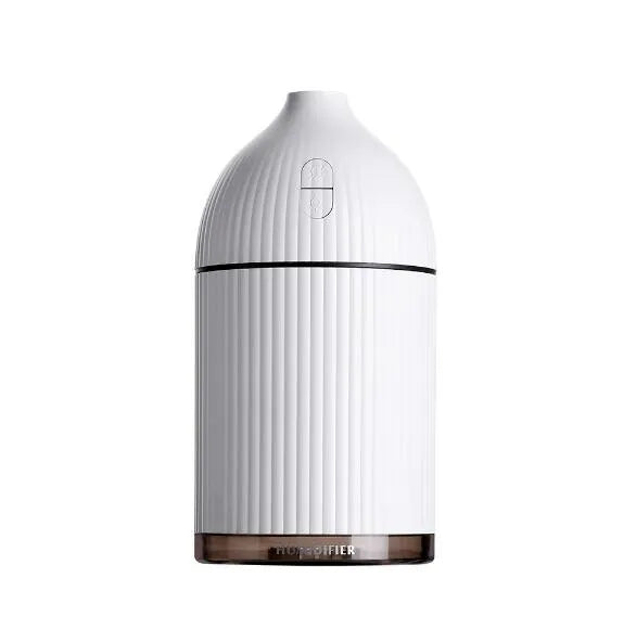 White ultrasonic aromatherapy diffuser with LED light and USB cable on a wooden table