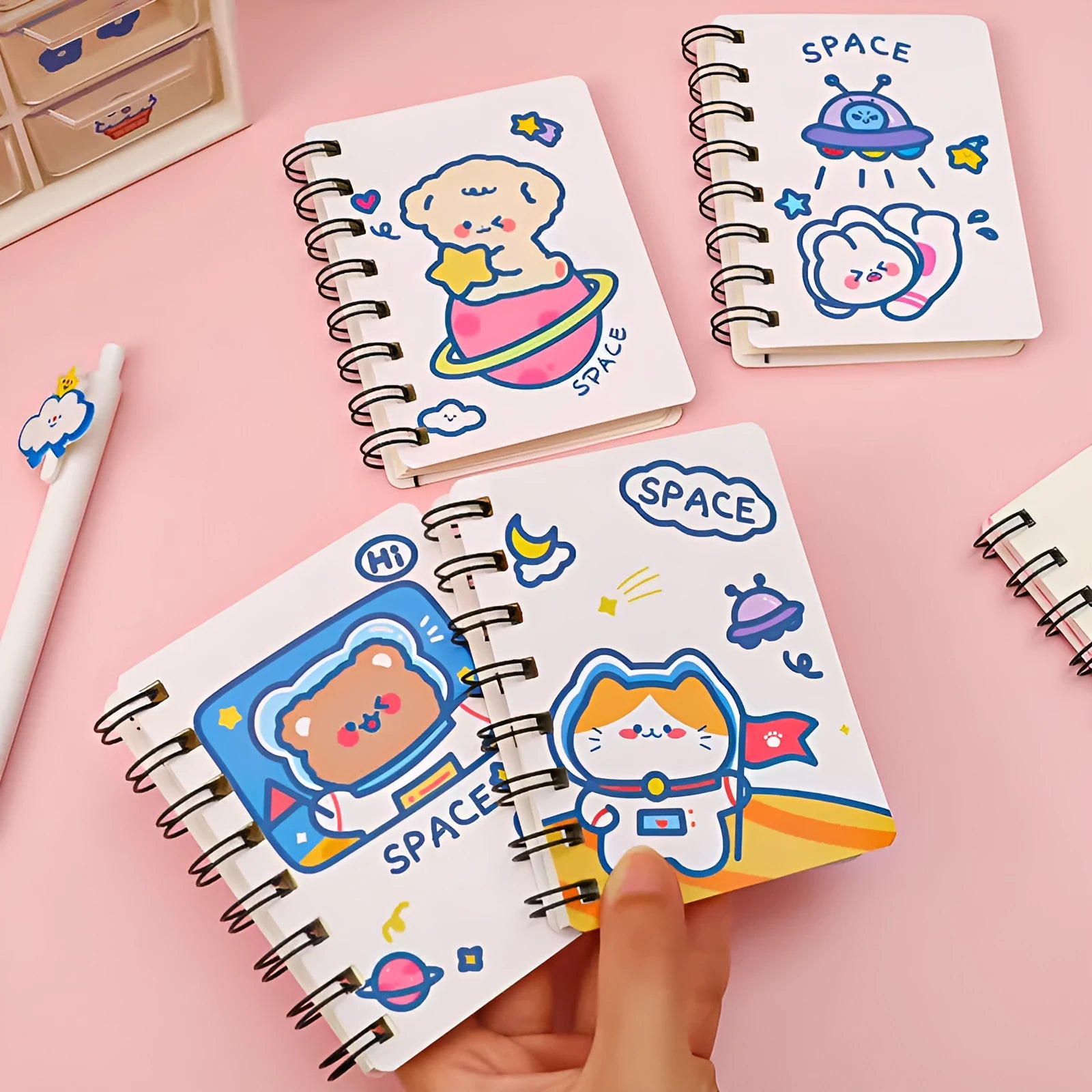 Astronaut flipped portable pocket notebook showing space-themed cover designs at 10.5 by 8 cm size