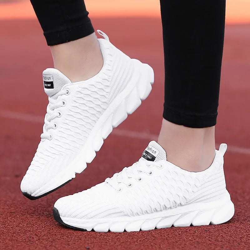 Women's running shoes with fly weave upper in Black, Pink, or White colours showing wear-resistant outsole