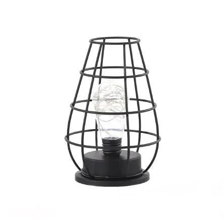 Minimalist hollow iron table lamp in red wine glass style on a wooden desk.